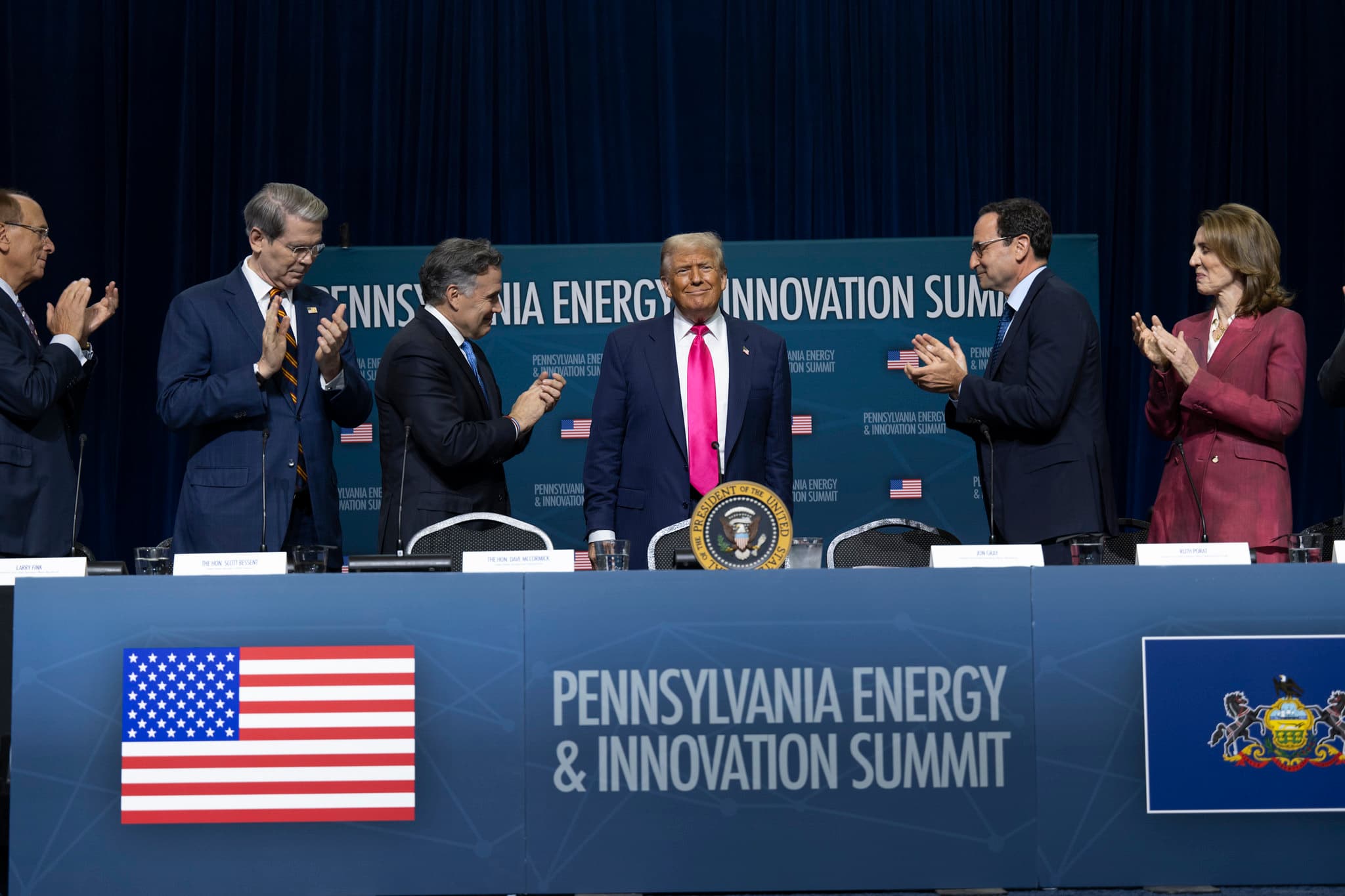 President Donald J. Trump at the Pennsylvania Energy and Innovation Summit, with industry leaders applauding.