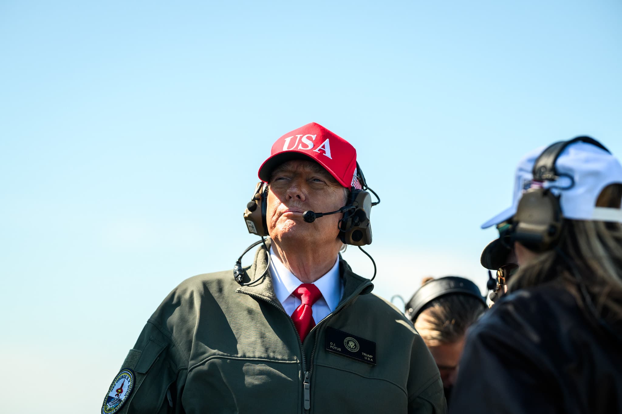 President Donald J. Trump in a USA cap and flight jacket aboard a U.S. Navy aircraft carrier.